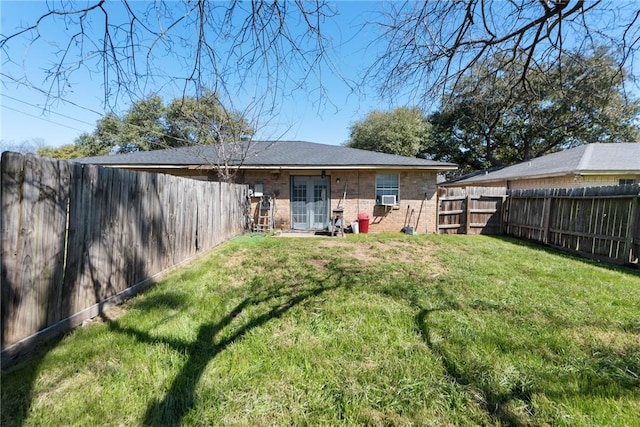 back of property featuring a yard, brick siding, and a fenced backyard