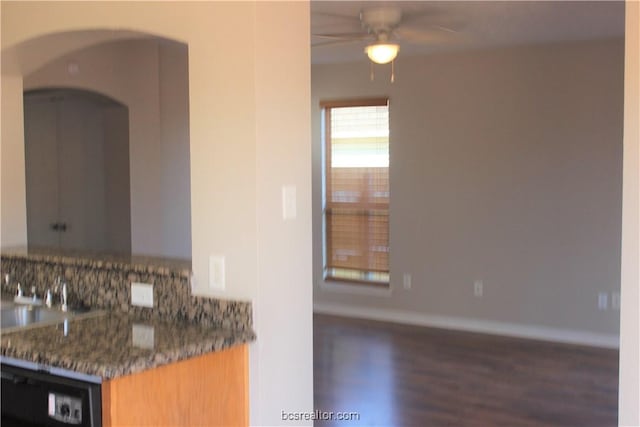 4031 Southern Trace Dr, College Station, TX 77845 - kitchen featuring a ceiling fan, wood finished floors, arched walkways, baseboards, and backsplash