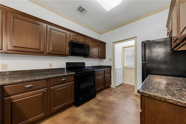 kitchen featuring visible vents, ornamental molding, dark countertops, black appliances, and washer / dryer