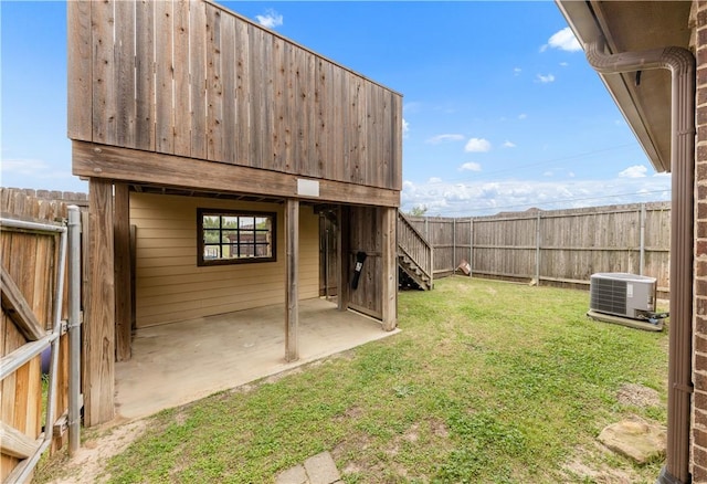 view of yard featuring a fenced backyard, central AC, and a patio area
