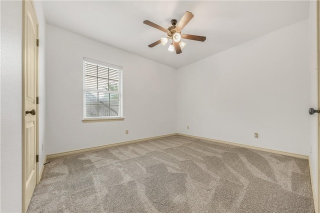 empty room featuring baseboards, ceiling fan, and carpet