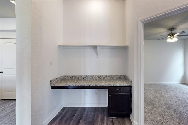 2038 Sorrento Ct, Bryan, TX 77808 - unfurnished office featuring ceiling fan, built in desk, and dark wood-type flooring