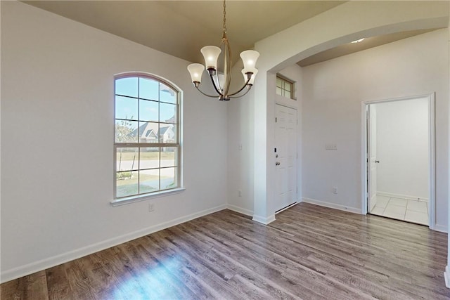 unfurnished dining area featuring hardwood / wood-style floors and a notable chandelier