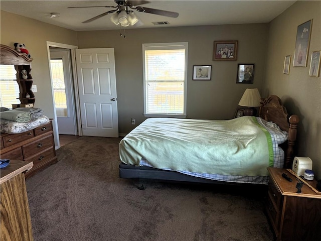 bedroom featuring dark colored carpet, ceiling fan, and multiple windows