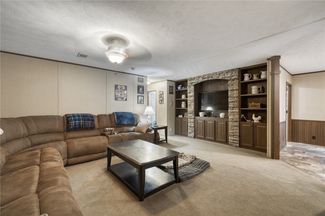 2095 Fm 1452 W, Madisonville, TX 77864 - living room featuring built in features, a textured ceiling, light carpet, crown molding, and a decorative wall