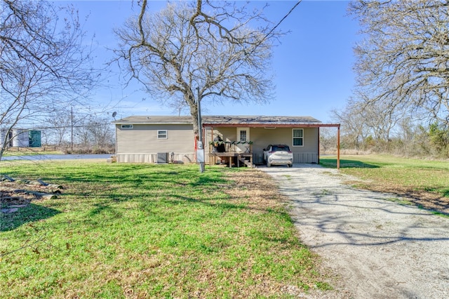 2095 Fm 1452 W, Madisonville, TX 77864 - back of house with driveway, a yard, and a carport
