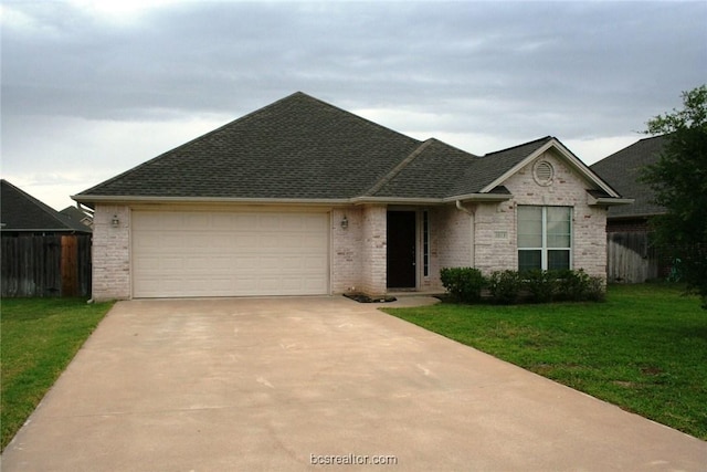 ranch-style home with an attached garage, fence, a front lawn, and concrete driveway