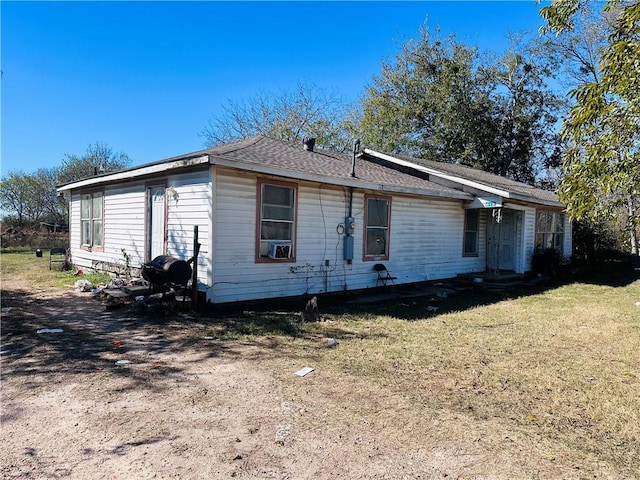 view of front of property with cooling unit and a front yard