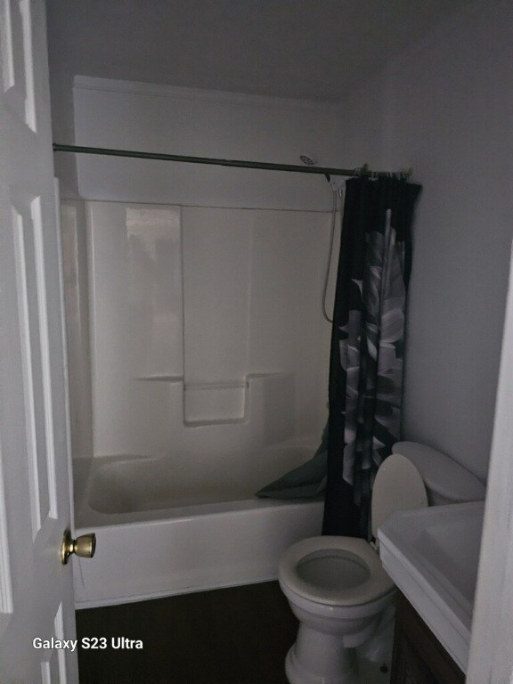 bathroom with toilet and shower / tub combo with curtain