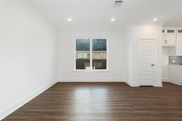 empty room featuring dark hardwood / wood-style floors and crown molding