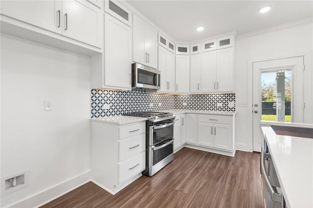 kitchen featuring white cabinets, dark hardwood / wood-style flooring, crown molding, and appliances with stainless steel finishes