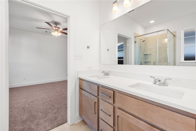 bathroom featuring tile patterned flooring, ceiling fan, a shower with shower door, and vanity