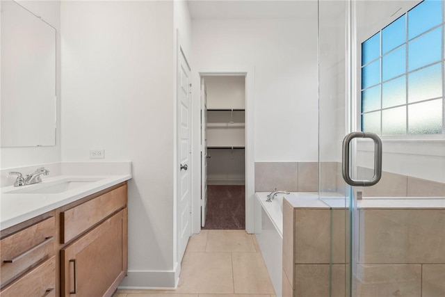 bathroom with tile patterned flooring, vanity, and a tub