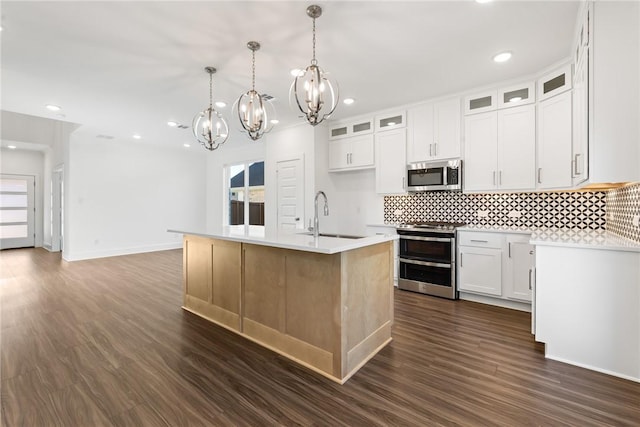 kitchen with sink, an island with sink, decorative light fixtures, white cabinetry, and stainless steel appliances