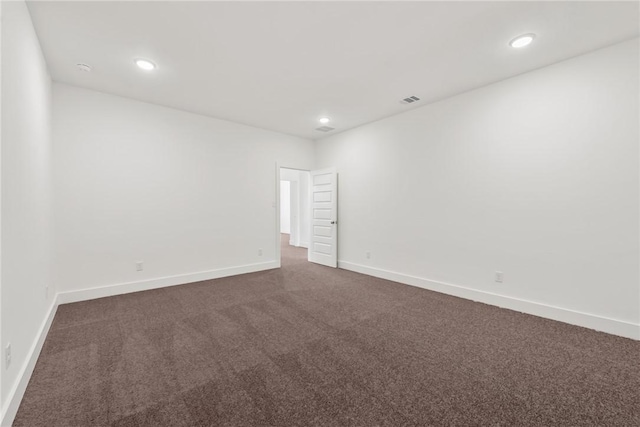 unfurnished room with dark colored carpet