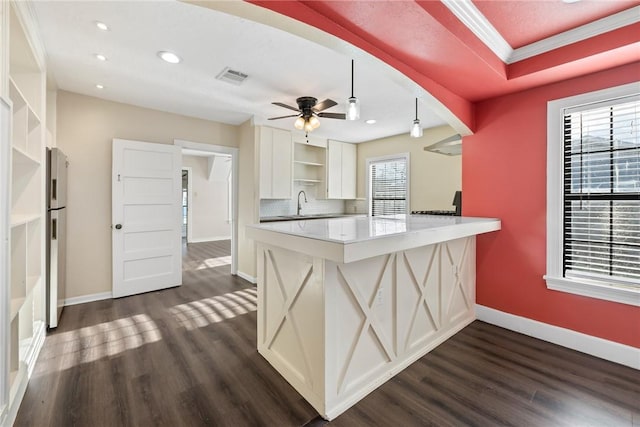 kitchen featuring white cabinetry, plenty of natural light, kitchen peninsula, and hanging light fixtures