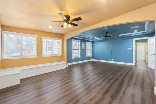 spare room with dark hardwood / wood-style floors, ceiling fan, and a tray ceiling