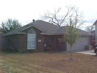 view of side of property with a lawn, a garage, and concrete driveway