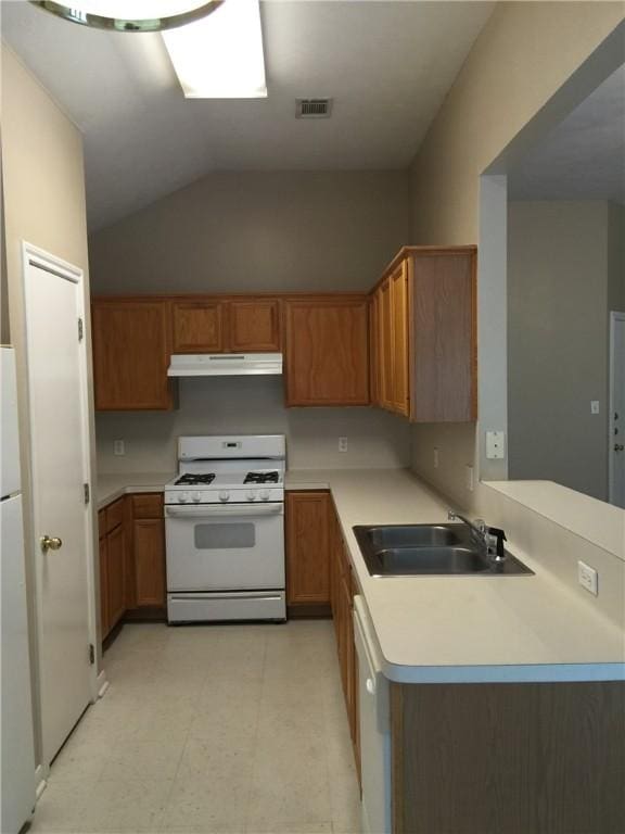 kitchen with a sink, light countertops, under cabinet range hood, light floors, and white appliances