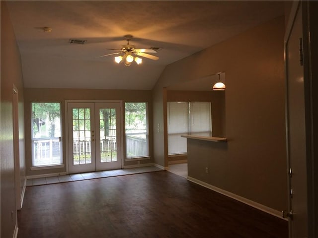 spare room with wood finished floors, a ceiling fan, visible vents, baseboards, and lofted ceiling