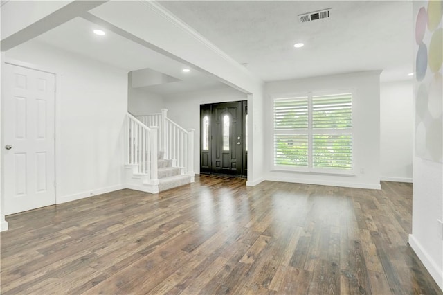 foyer entrance with dark wood-type flooring and ornamental molding