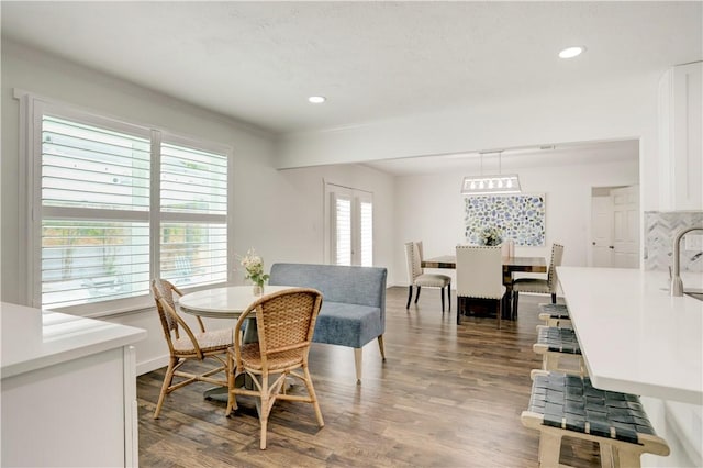 dining area with plenty of natural light, sink, wood-type flooring, and ornamental molding