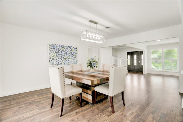 dining room with hardwood / wood-style floors and ornamental molding