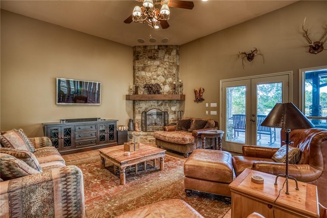 living room with a fireplace, ceiling fan, french doors, and lofted ceiling