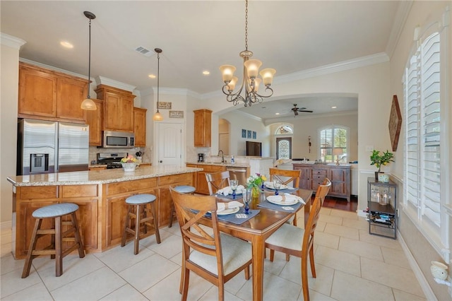 dining space featuring light tile patterned floors, visible vents, arched walkways, ornamental molding, and ceiling fan with notable chandelier