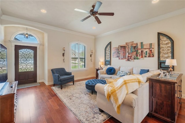 living room featuring ornamental molding, a ceiling fan, baseboards, and dark wood-style flooring