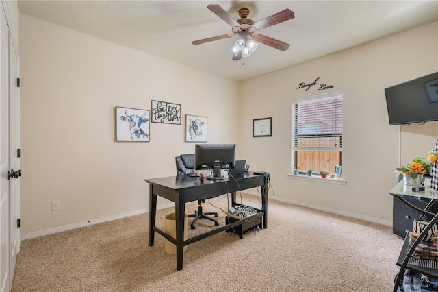 office featuring baseboards, light carpet, and a ceiling fan