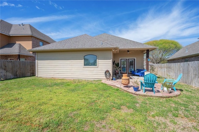 rear view of house with a ceiling fan, a fenced backyard, french doors, a patio area, and a lawn