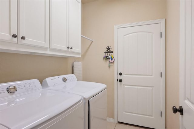 laundry area with washer and clothes dryer, light tile patterned floors, and cabinet space