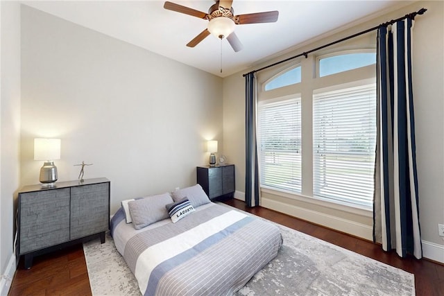 bedroom with baseboards, wood finished floors, and a ceiling fan