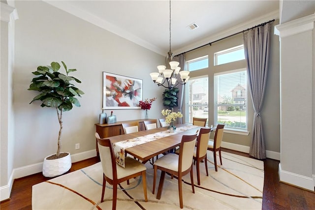 dining space with baseboards, wood finished floors, a chandelier, and ornamental molding