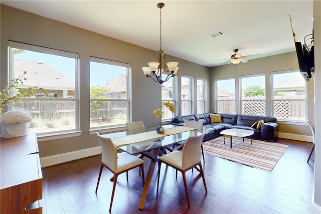 dining space with healthy amount of natural light, wood finished floors, baseboards, and a chandelier