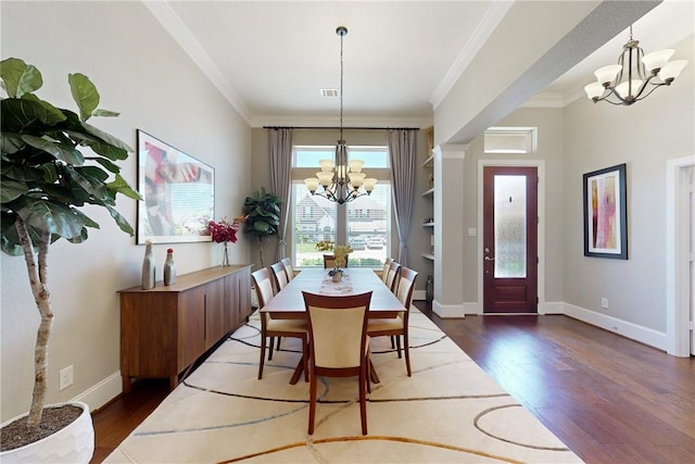 dining area with a chandelier, wood finished floors, crown molding, and baseboards