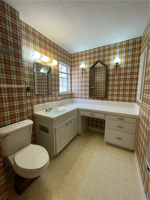 bathroom with a textured ceiling, tile patterned floors, toilet, and wallpapered walls