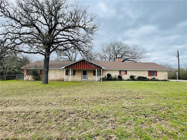 ranch-style house featuring board and batten siding, a front yard, and a chimney