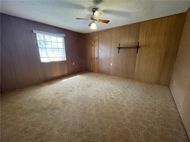 carpeted spare room with a textured ceiling and a ceiling fan