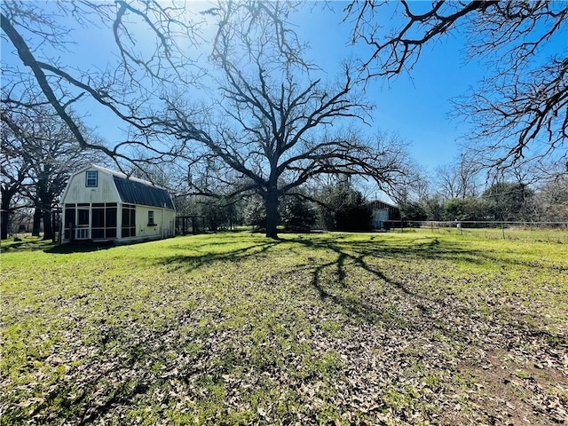 view of yard featuring an outdoor structure, a barn, and fence