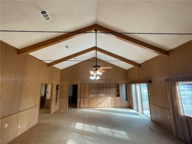 spare room featuring carpet floors, beamed ceiling, and wooden walls