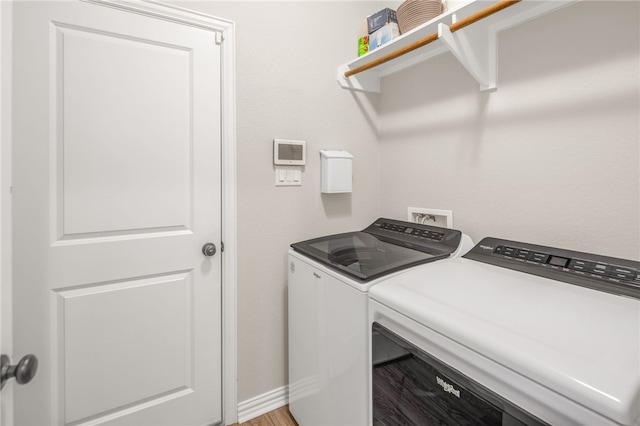 clothes washing area featuring laundry area, washer and clothes dryer, and baseboards