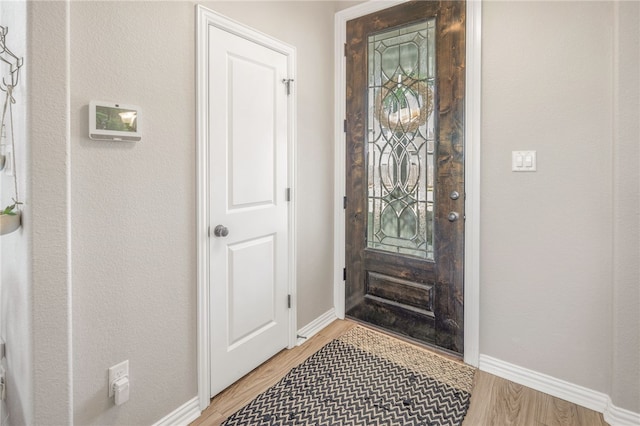 foyer entrance with baseboards and wood finished floors