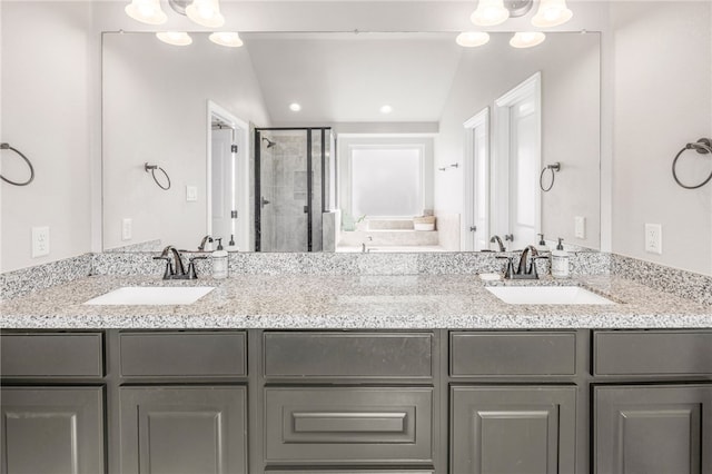 full bath featuring double vanity, a shower stall, and a sink