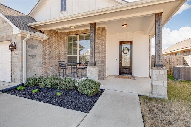 property entrance featuring a porch, board and batten siding, an attached garage, and brick siding