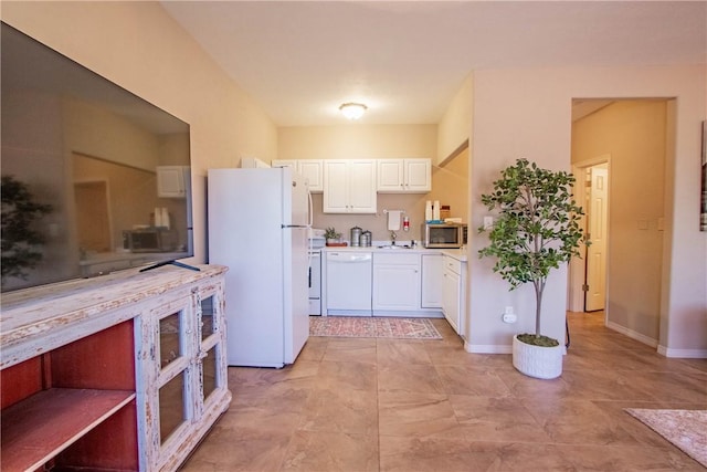 kitchen with white cabinets, white appliances, and sink