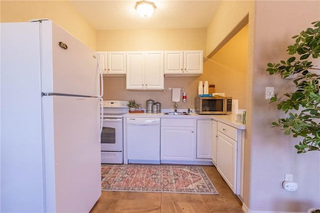 kitchen with tile patterned flooring, white cabinetry, white appliances, and sink