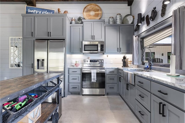 1923 County Road 202, Caldwell, TX 77836 - kitchen featuring stainless steel appliances, gray cabinets, a sink, light stone counters, and finished concrete floors