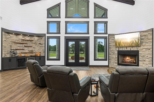 1923 County Road 202, Caldwell, TX 77836 - living area featuring a high ceiling, wet bar, a stone fireplace, wood finished floors, and french doors